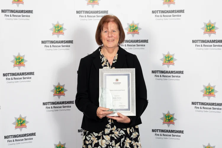 Wendy Fletcher poses with her Lifetime Achievement award certificate and glass flame.