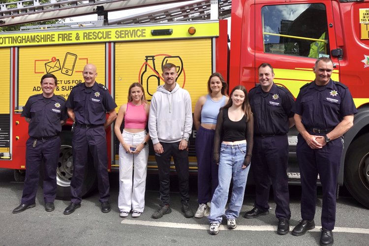 Firefighters and students stood in front of a fire engine.