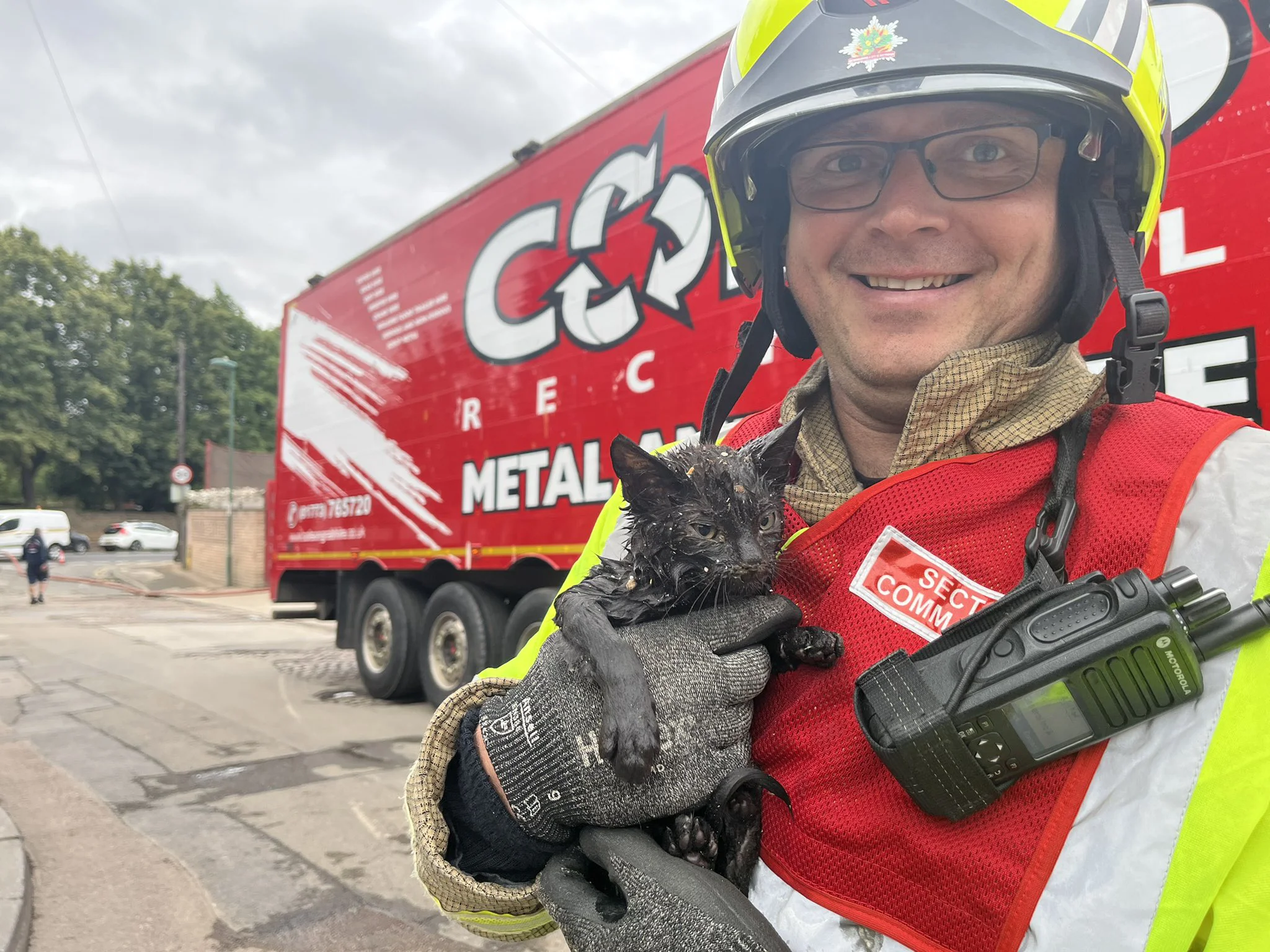 Cat being held by Firefighter after being rescued from fire