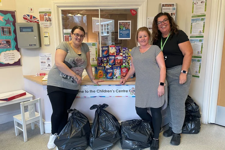 Three women standing in front of 20 Easter Eggs at a Children's Centre