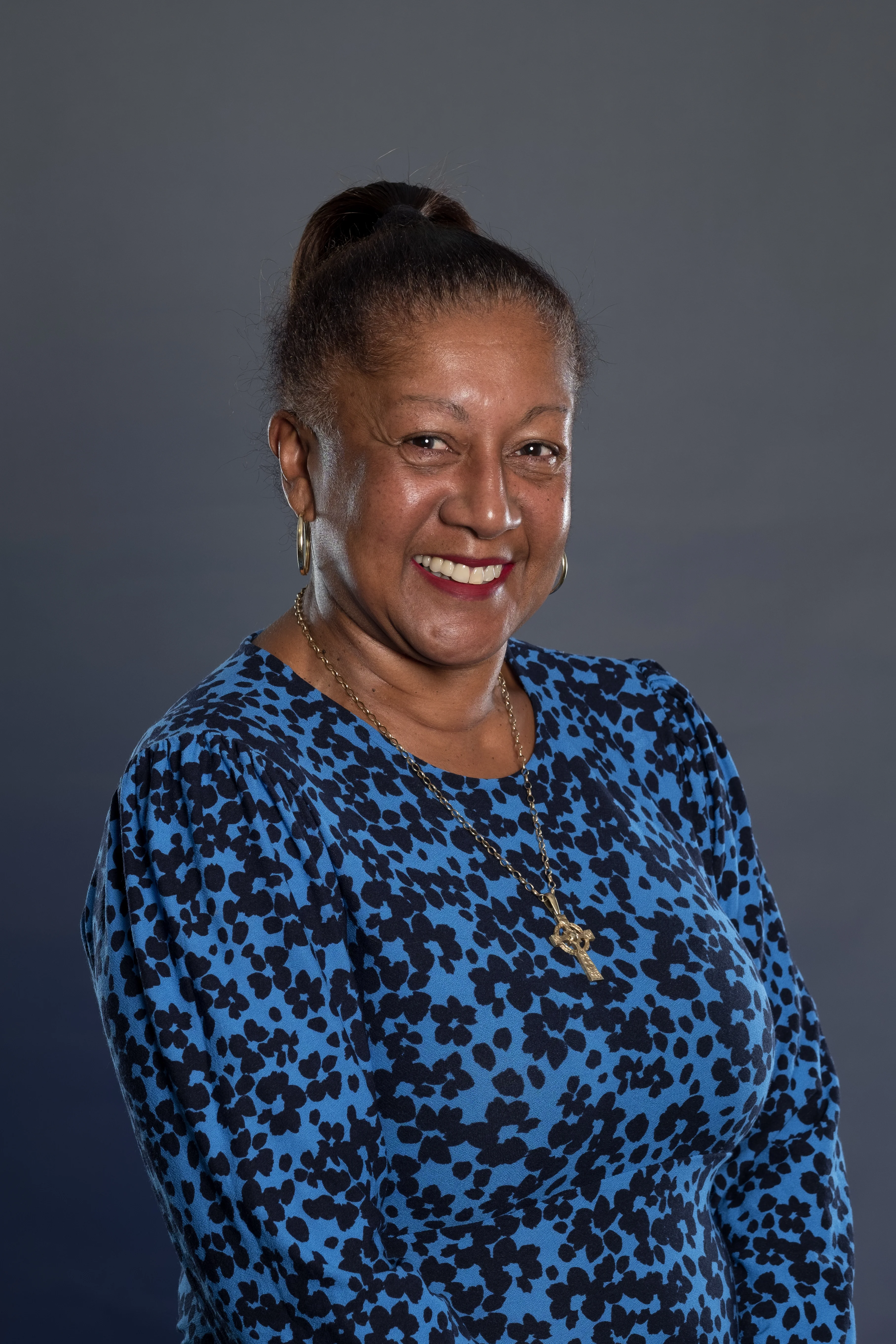 Michelle smiles in a blue dress with black spots on.