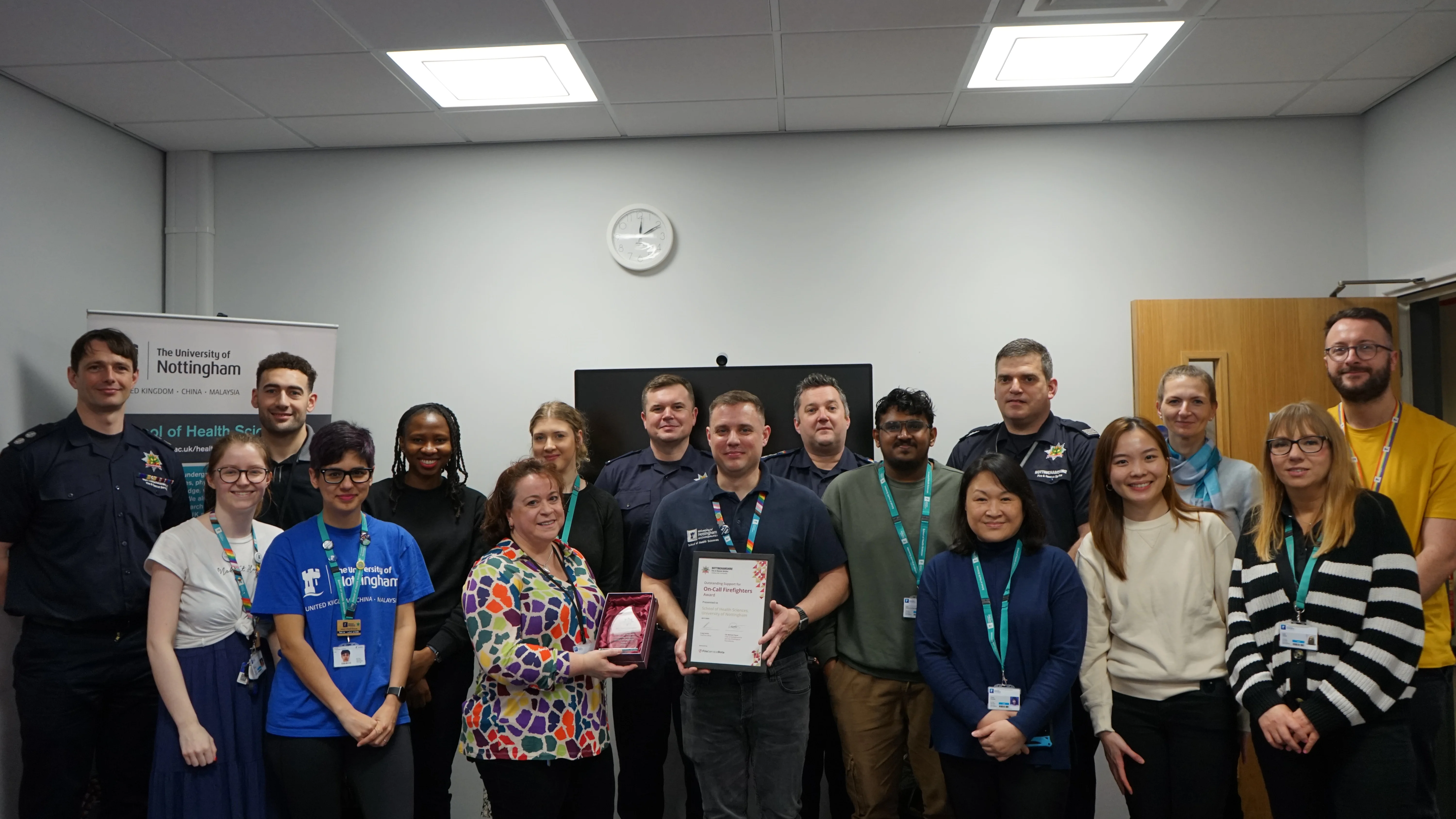 Aaron in the centre holding the award, flanked by students and members of staff.