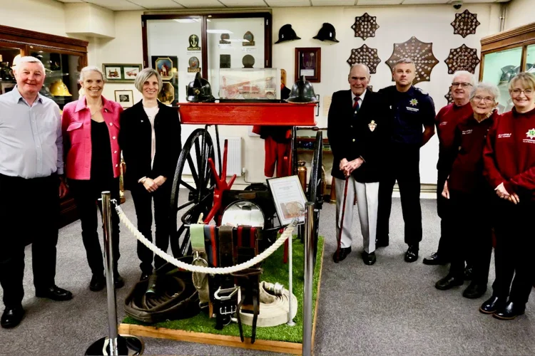 Landscape photo of seven people at Mansfield Fire Museum including Chief Fire Officer