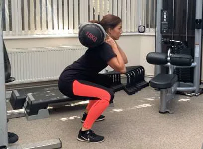 Demonstration of a squat with added weight