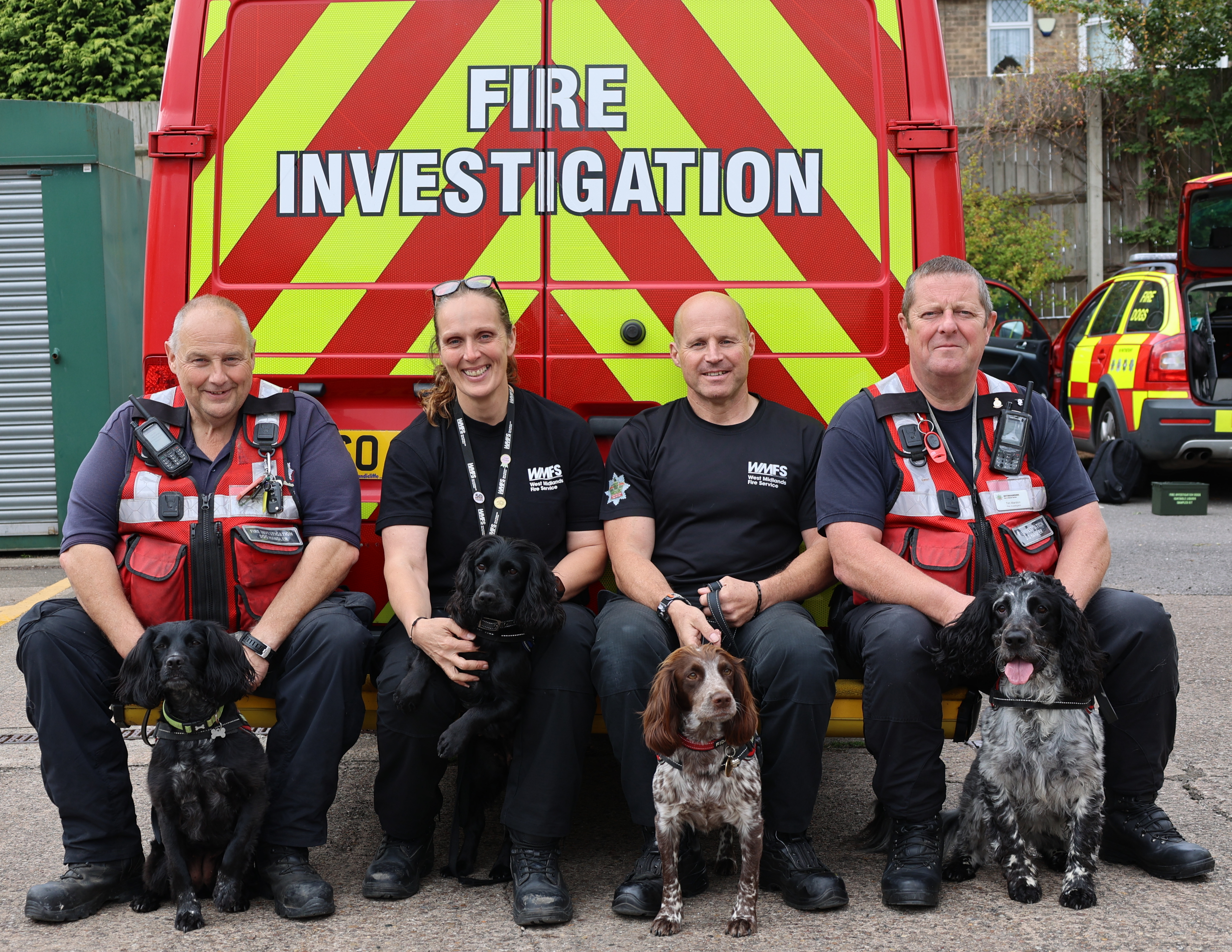 FI dogs and handlers sat in front of FI van