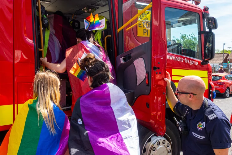 Firefighters showing three members of the public around a fire engine during Worksop Pride