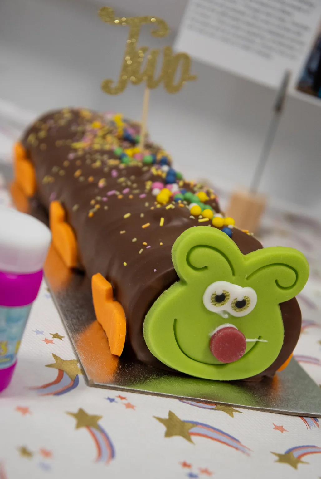 a caterpillar cake with a 'two' stick in it