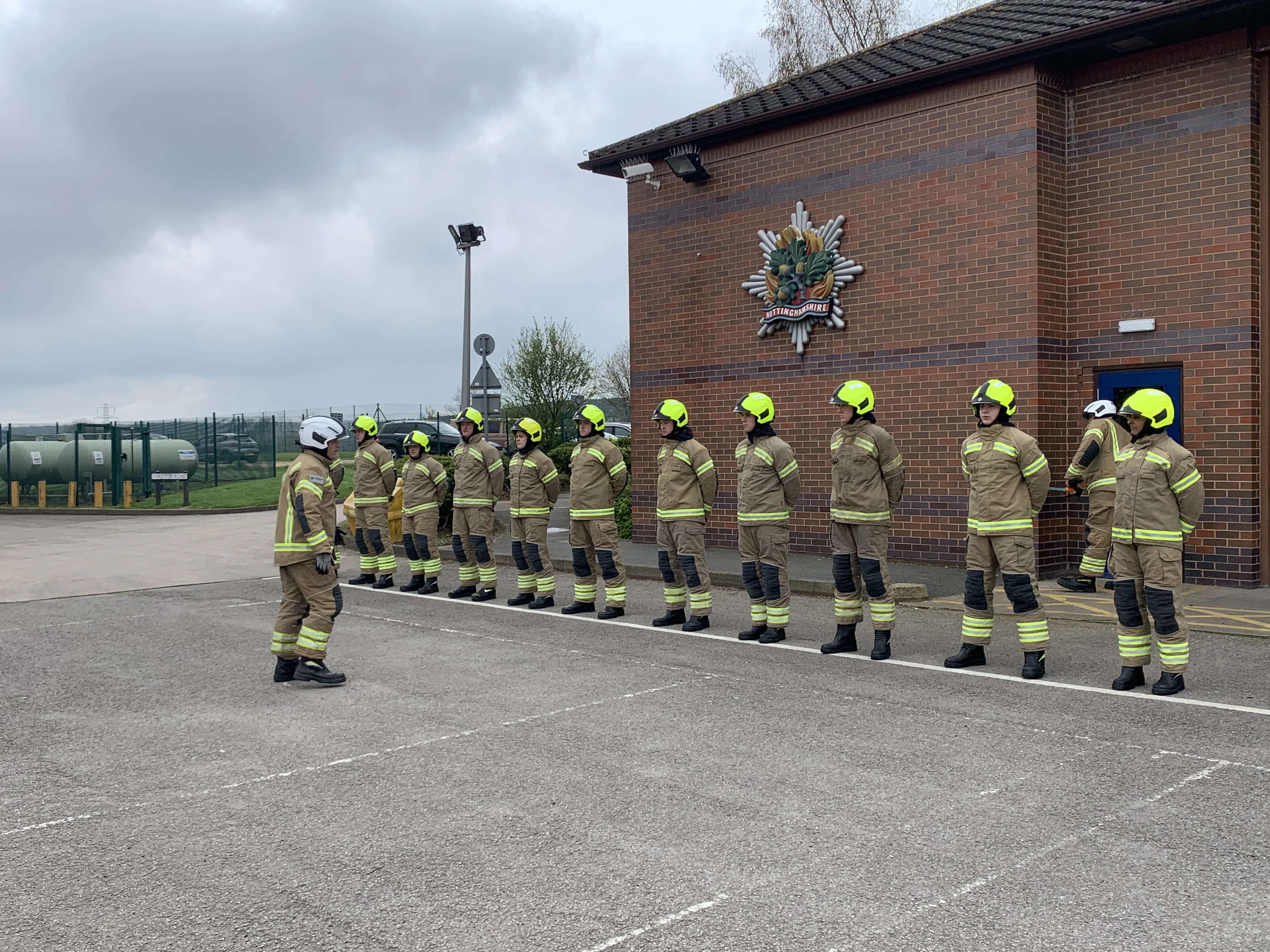 a group of firefighters stand in a line in full fire kit