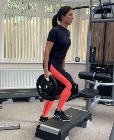 A women holding weights stepping onto a block