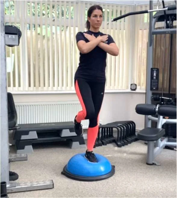 a women balancing on one leg on a bosu ball