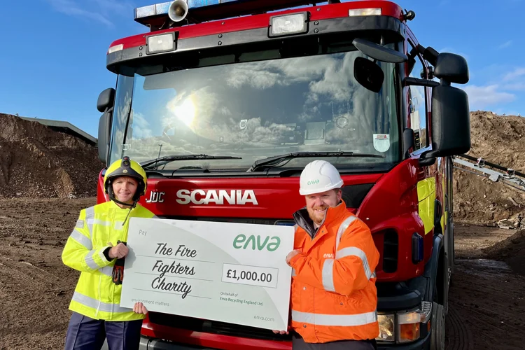 Firefighter Arron Enever poses with a staff member of Enva with the big cheque.