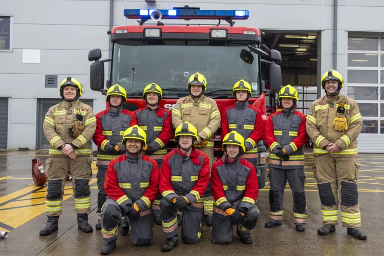 Firefighters and soldiers stood in front of the fire engine