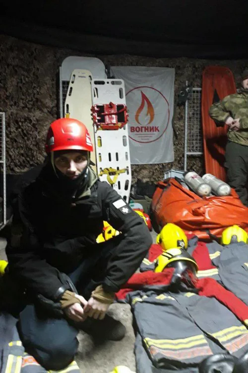 A Ukraine rescuer poses with old fire kit