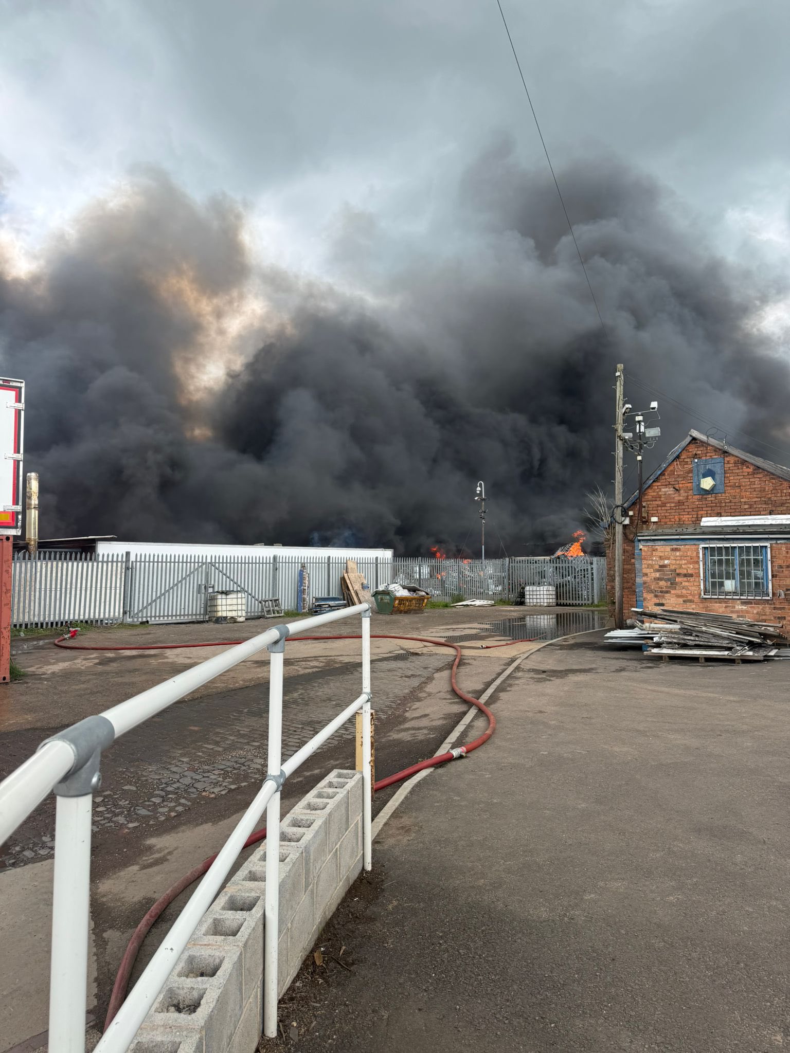 Fire at an industrial site in Sutton Bonington, image shows a large amount of thick black smoke the other side of a security fence.