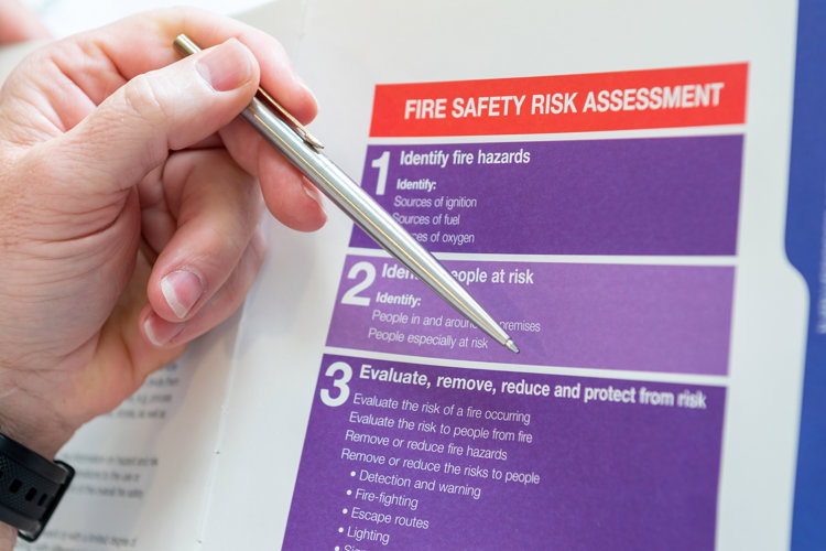Pen point at step three of the fire safety risk assessment checklist