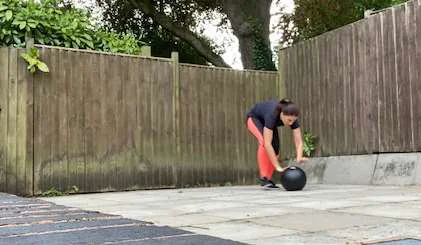 A women rolling a medicine ball