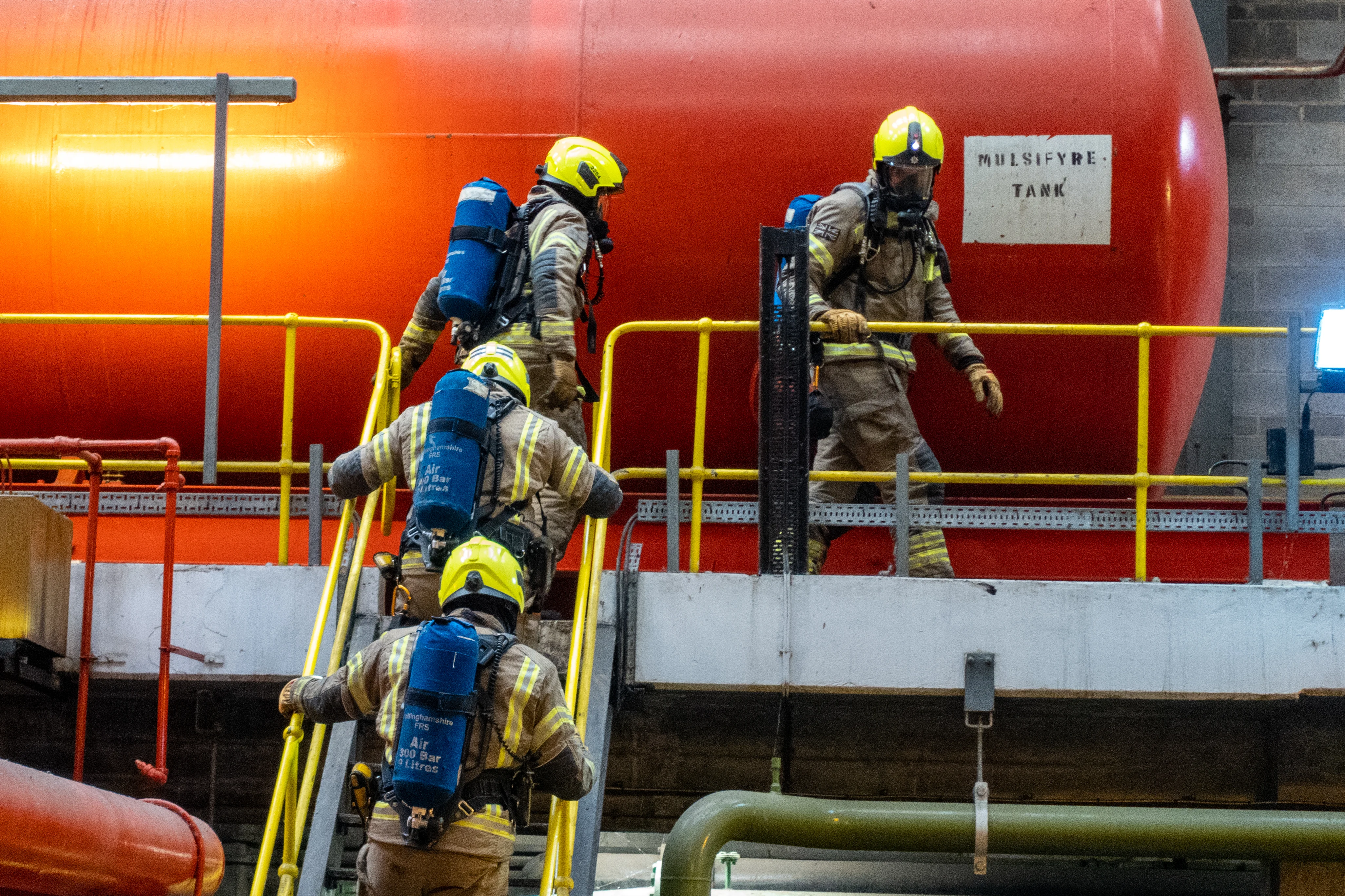 Four firefighters climbing stairs.