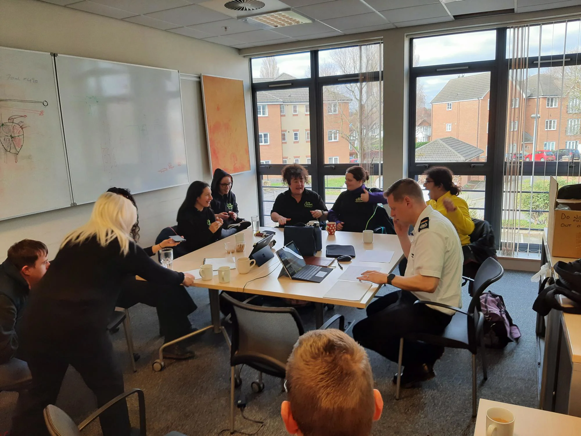 members of pulp friction sit around a table with an officer