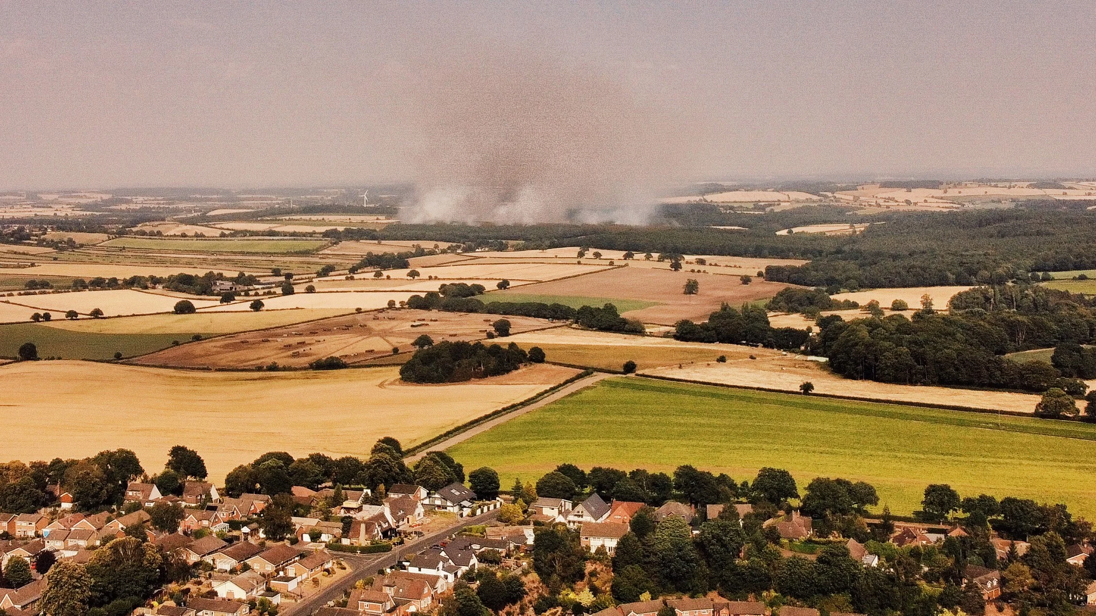 Smoke seen rising from a forest in the distance at Blidworth Lane.