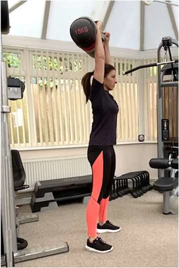 A women holding a weighted back above her head, arms fully extened.