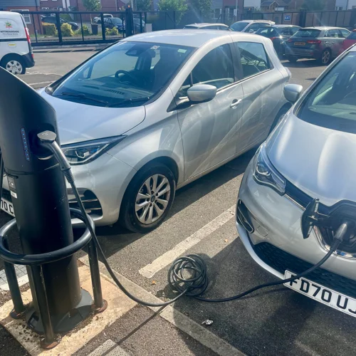 Two electric cars plugged into a charging point