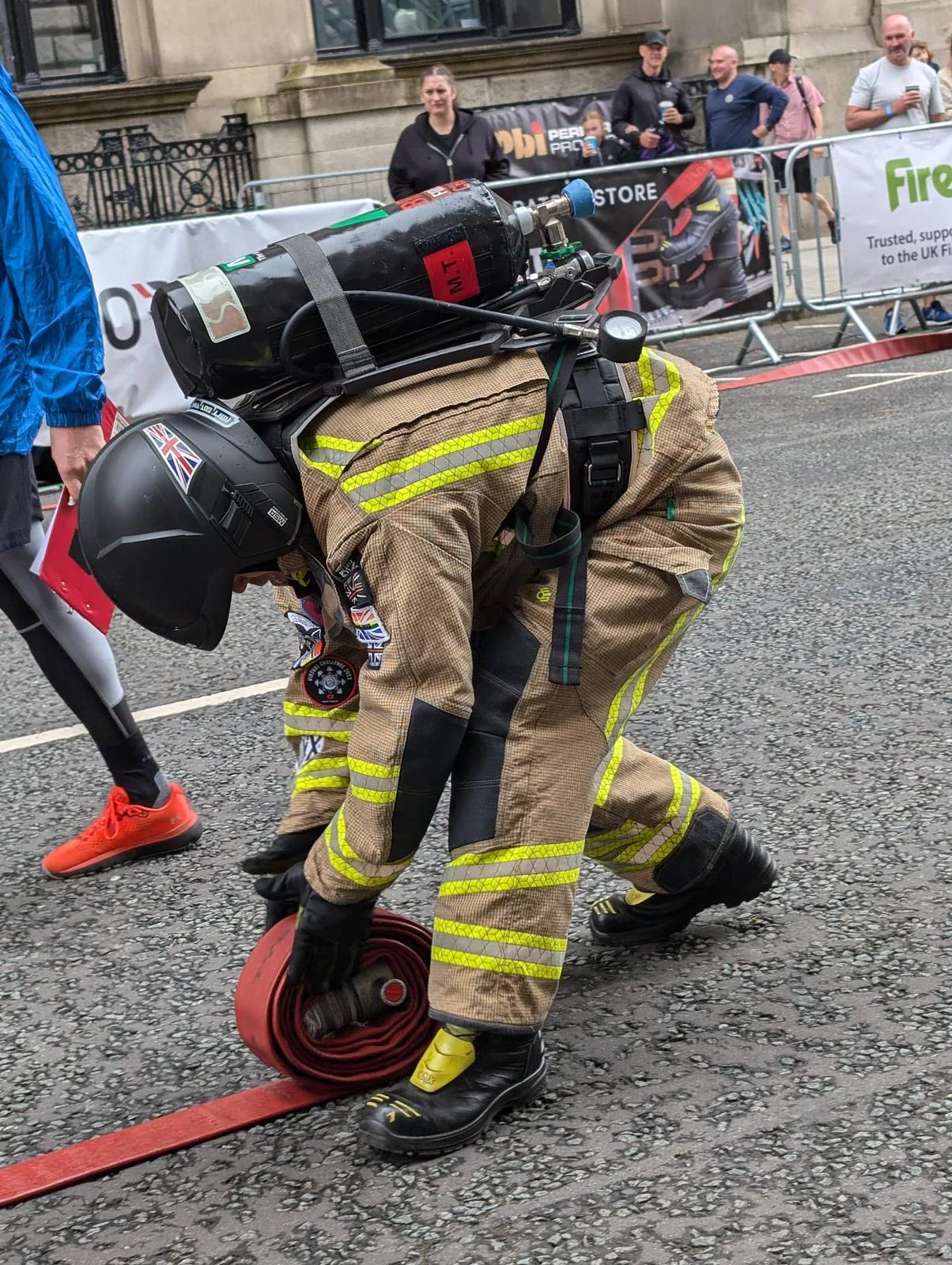 a firefighter rolls up a hose reel