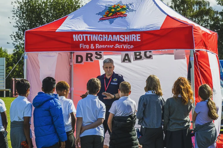 A member of the Education Team speaks to a group of schoolchildren.