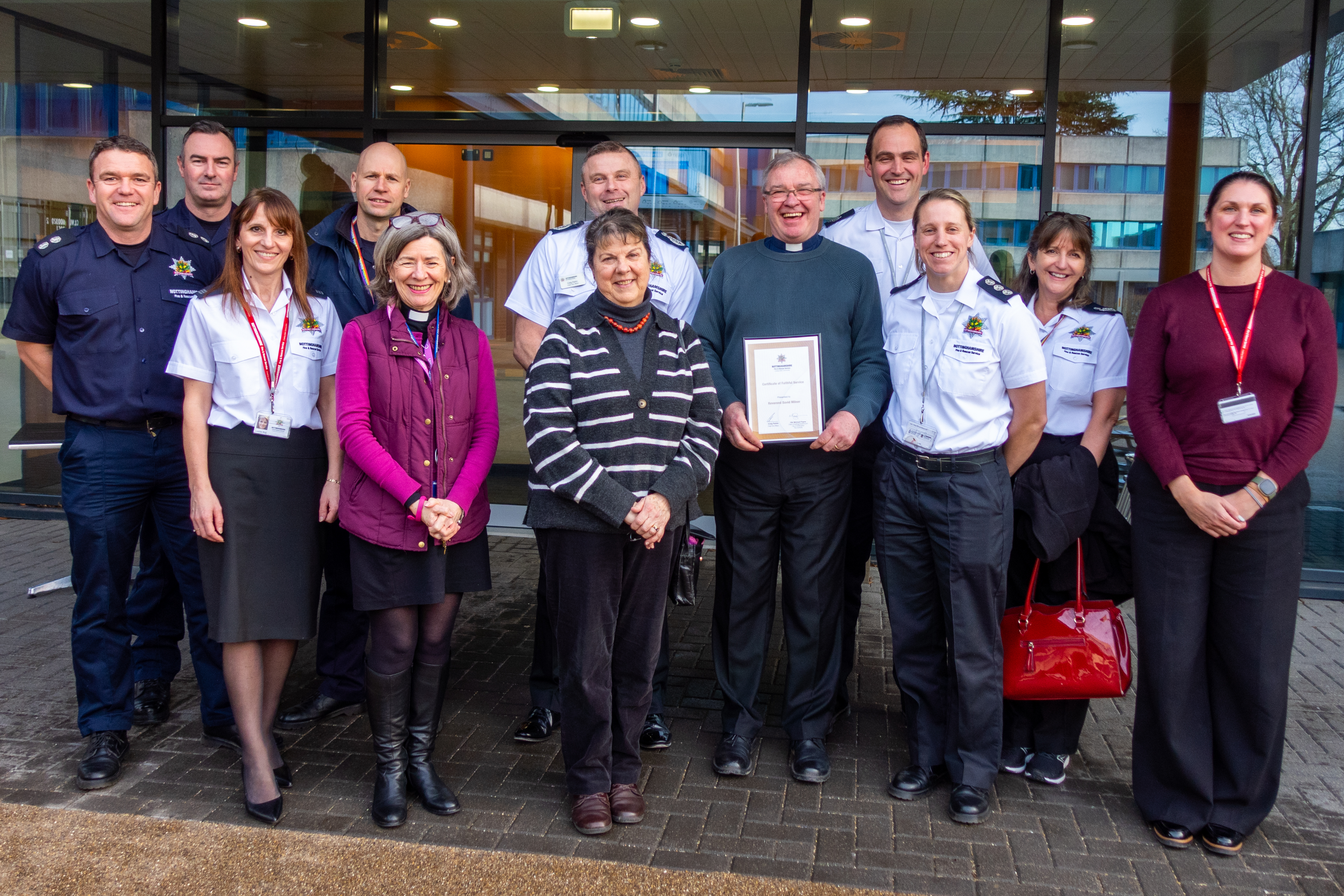 David Milner poses with his certificate surrounded by fire service staff.