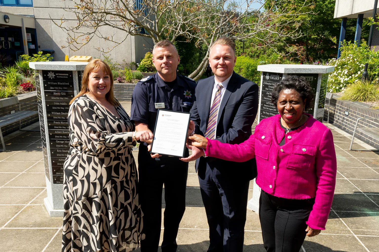 from left to right, the PCC, Chief Fire Officer, Chair of the Fire Authority, and Deputy Chair, stand in a line holding a certificate