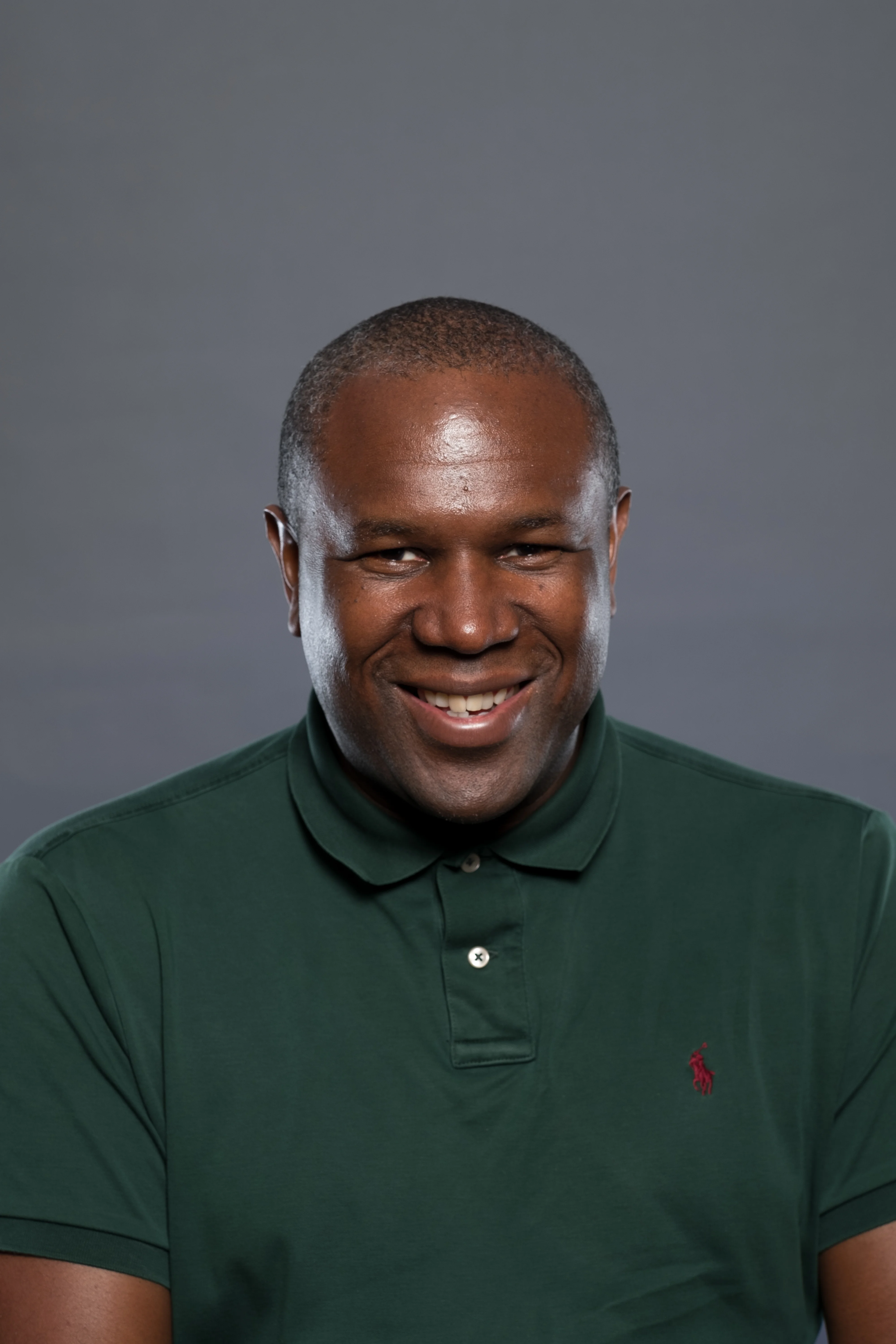 Michael smiles for the camera wearing a green polo shirt.