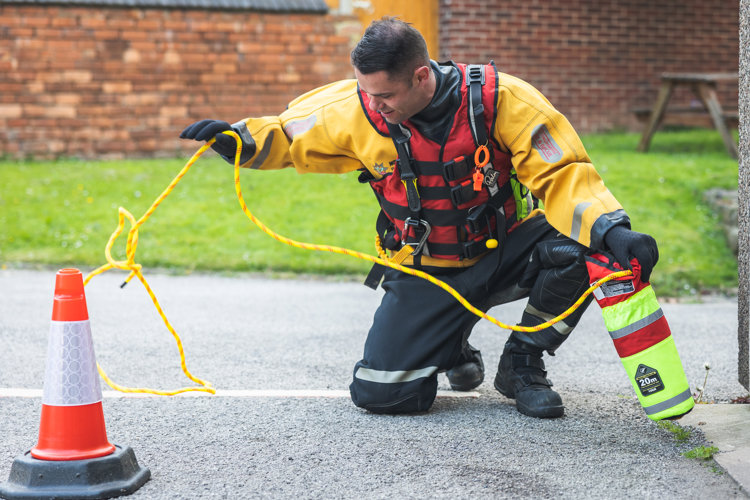 Firefighter demonstrating how to use a throw line.