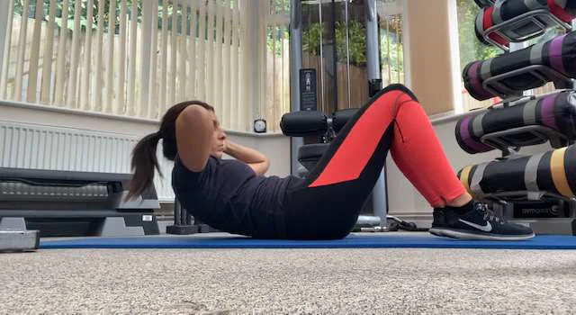 An abdominal crunch viewed from the side at ground level