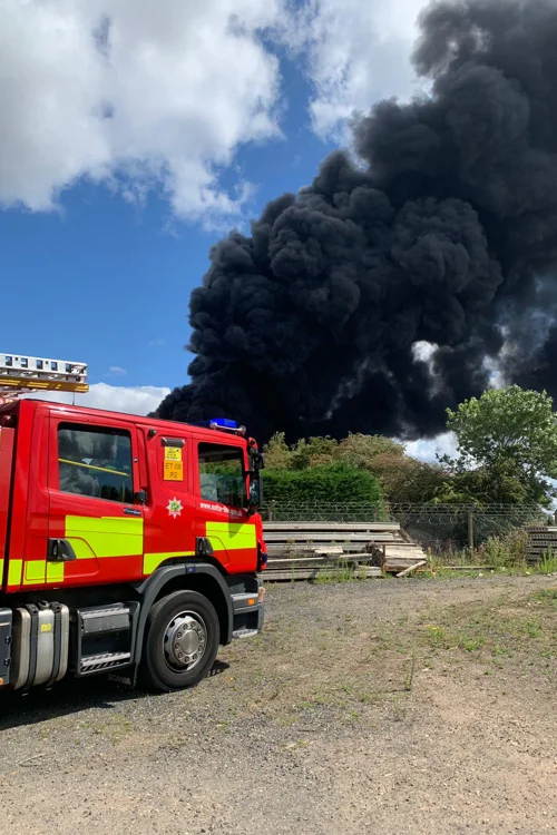 Fire engine with a large black smoke cloud behind it