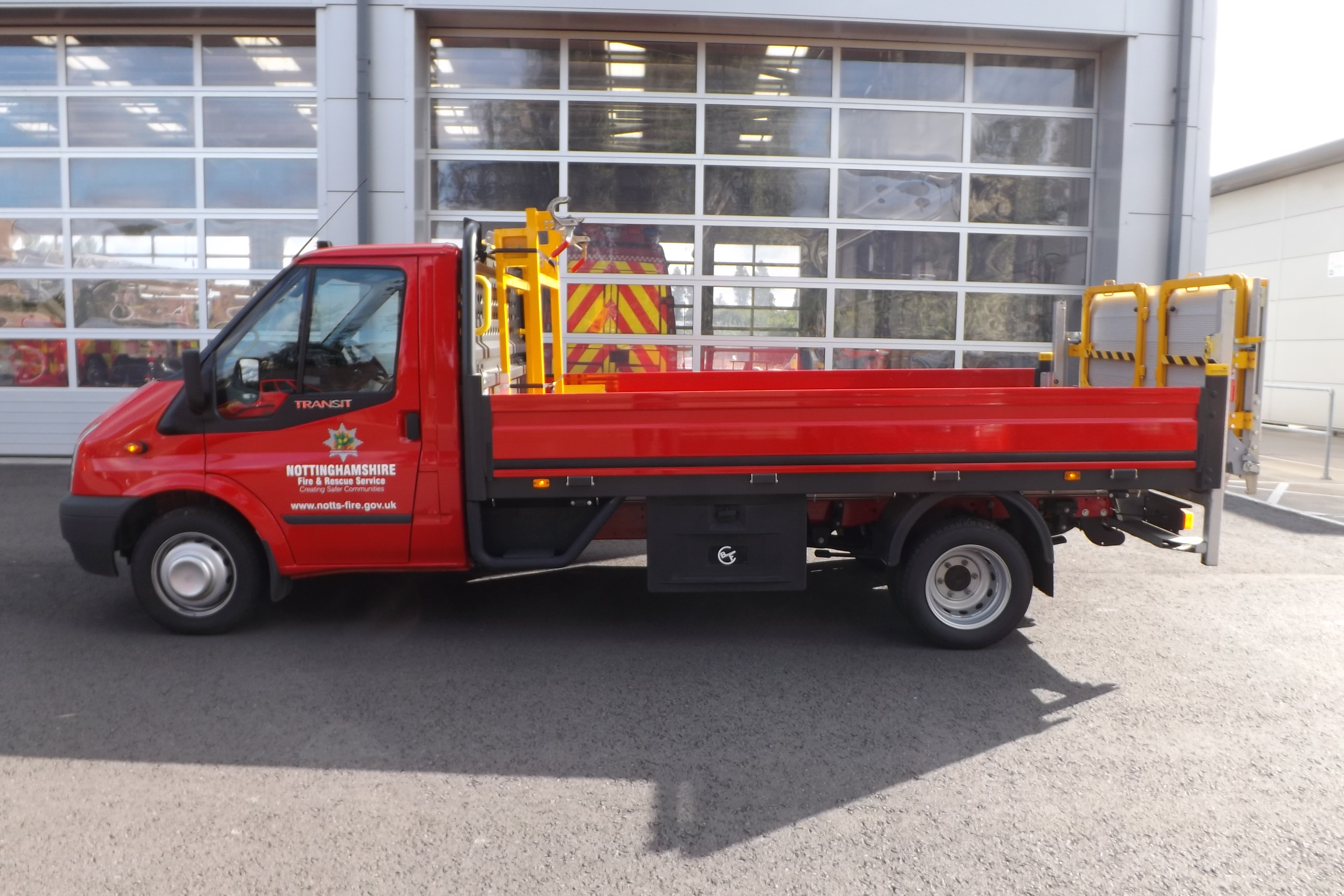 Side view of a red ford van with notts fire logo on