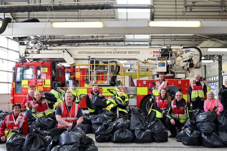 14 volunteers with bagged up Easter Eggs in front of the Aerial Ladder Platform