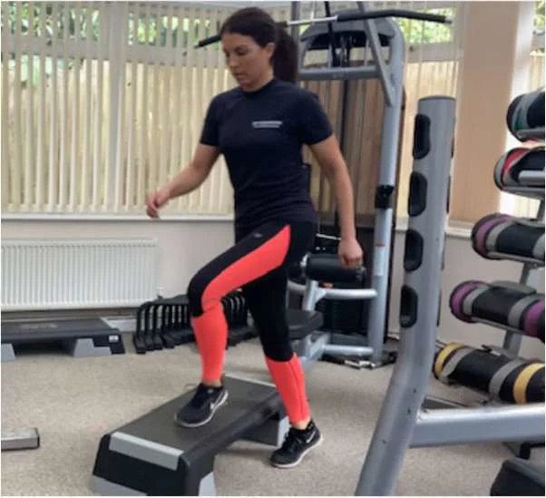 A women exercising with a step