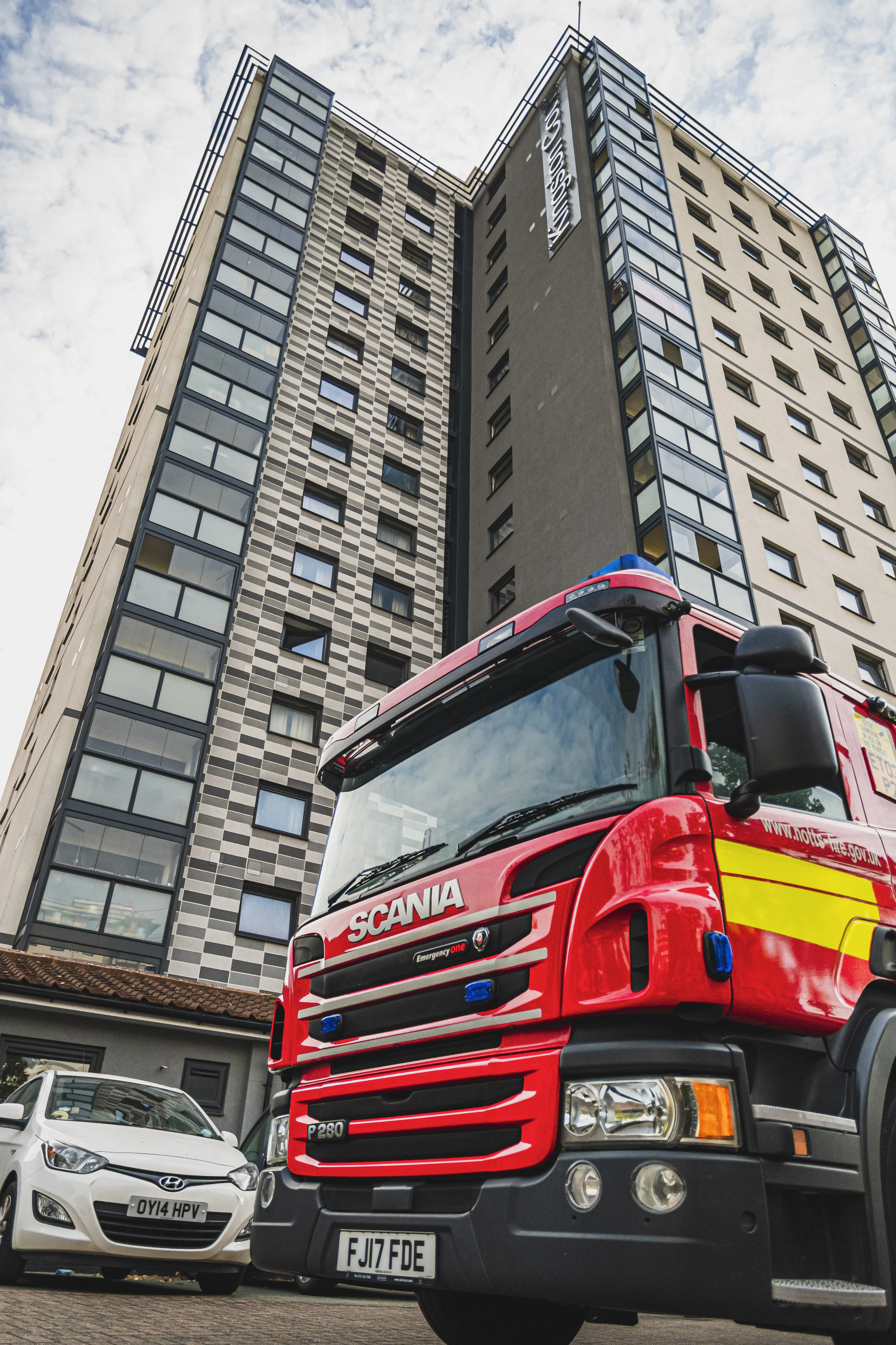 a high rise building with a fire engine in the foreground