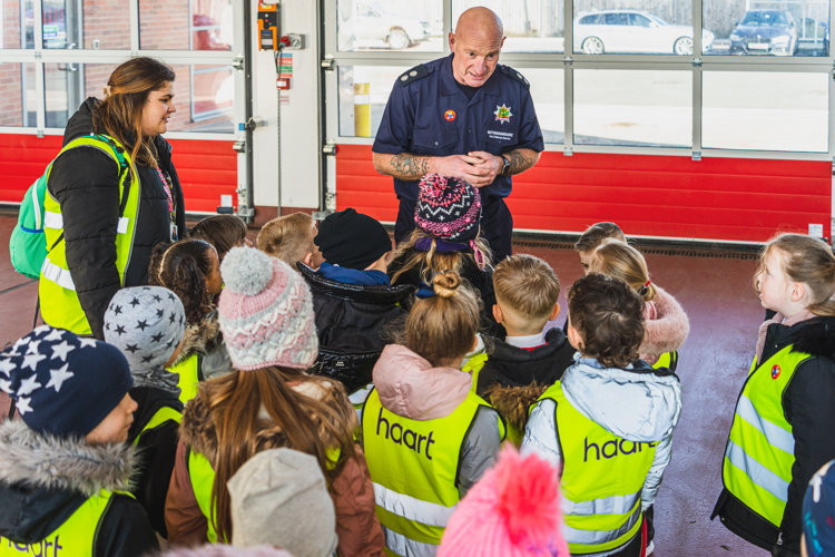 Firefighter instructing a school class on a visit to a fire station