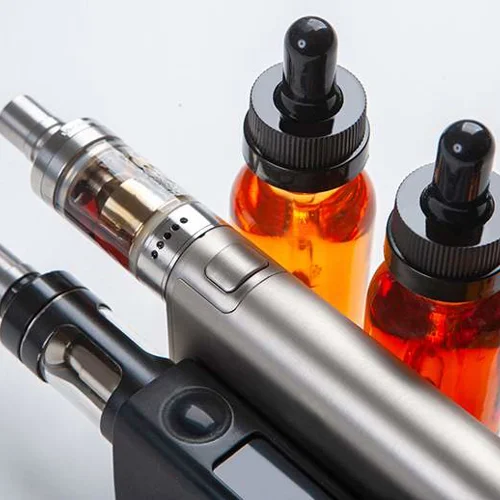 Two e-cigarettes next to re-fills