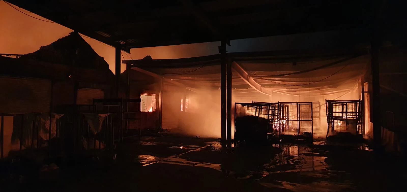 photo of a burnt building with orange glow from a fire.